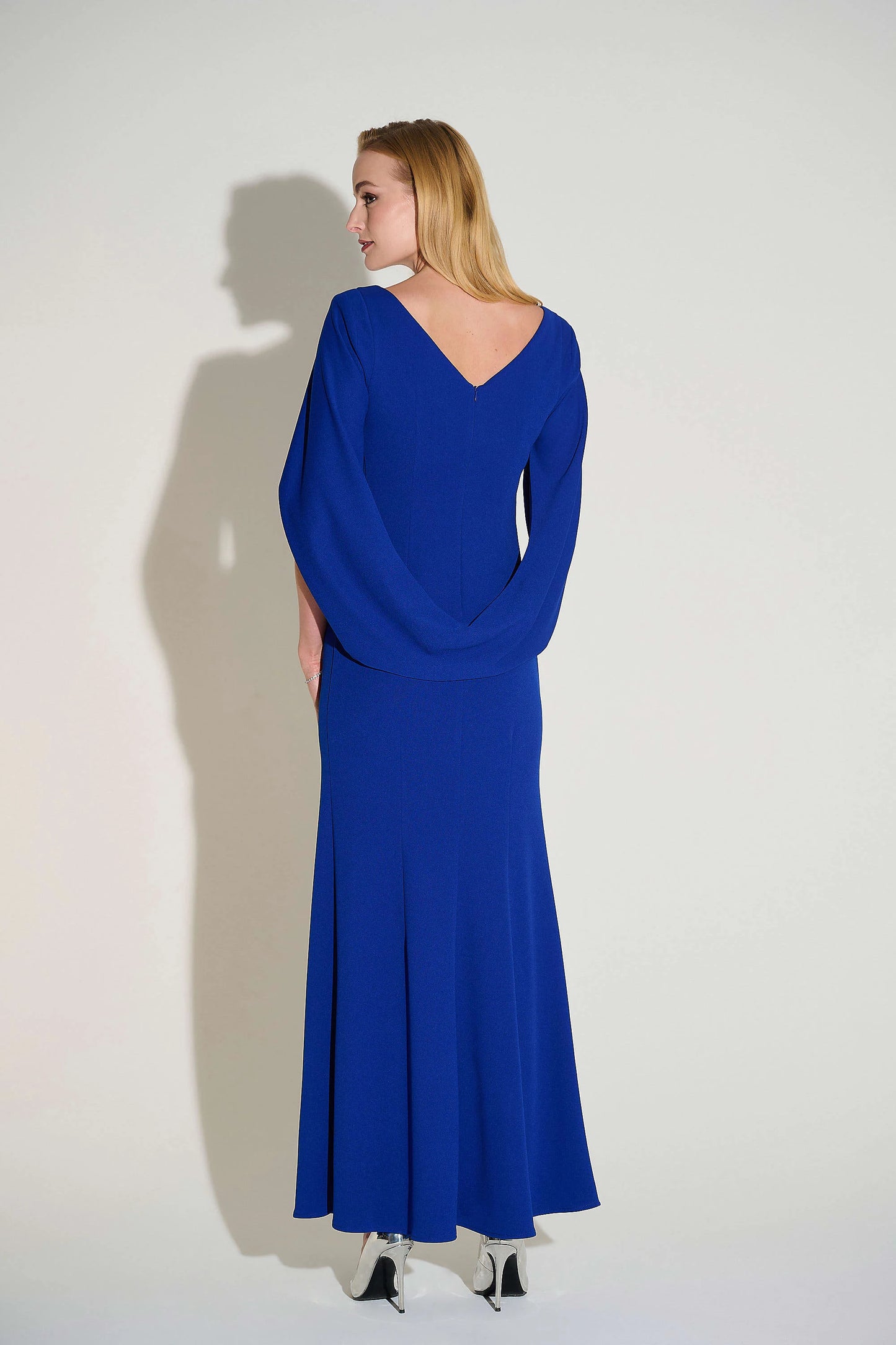 Robe de soirée longue avec coupe trompette, corsage drapé et manches plissées légères, offrant une allure élégante et saisissante
