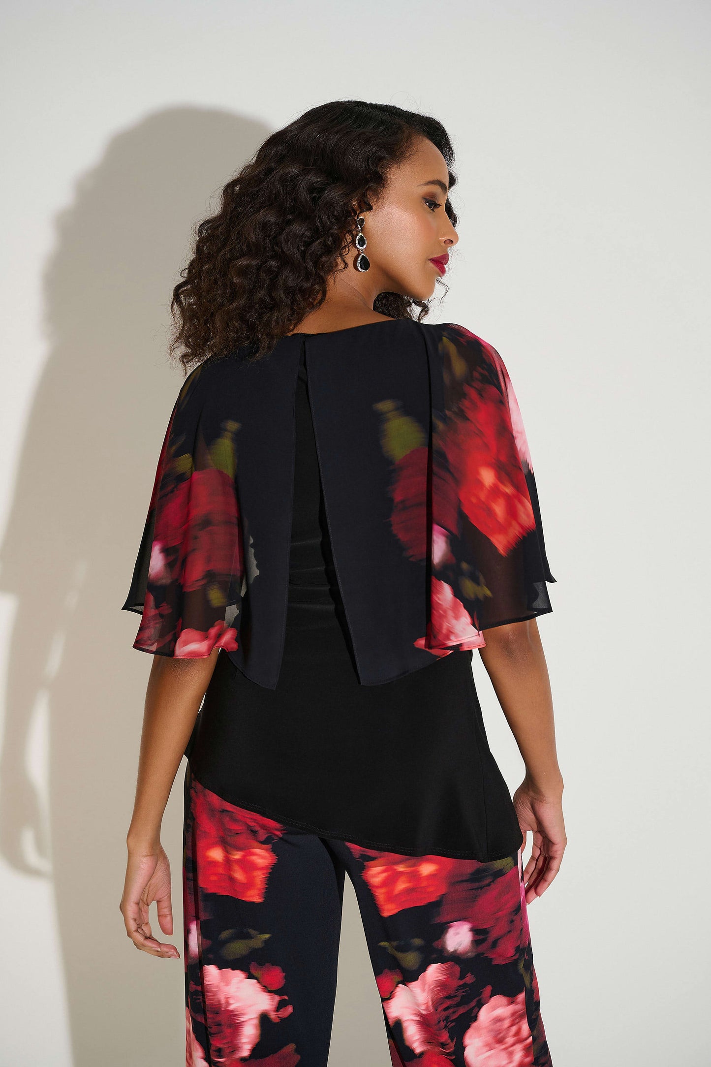 Haut en tricot soyeux vu de dos avec imprimé floral vibrant et manches courtes en mousseline fluide