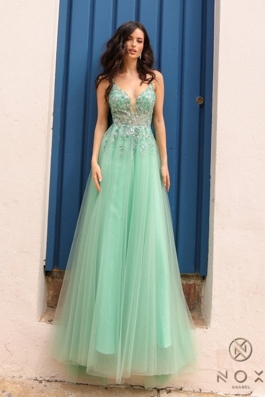 Vue de face d'une femme portant une robe de bal longue dotée d'un corsage ajusté avec un décolleté en V plongeant et empiècement en tulle illusion transparent, richement orné de broderies florales de sequins argentés brillants et d'une jupe évasée en tulle vaporeux.