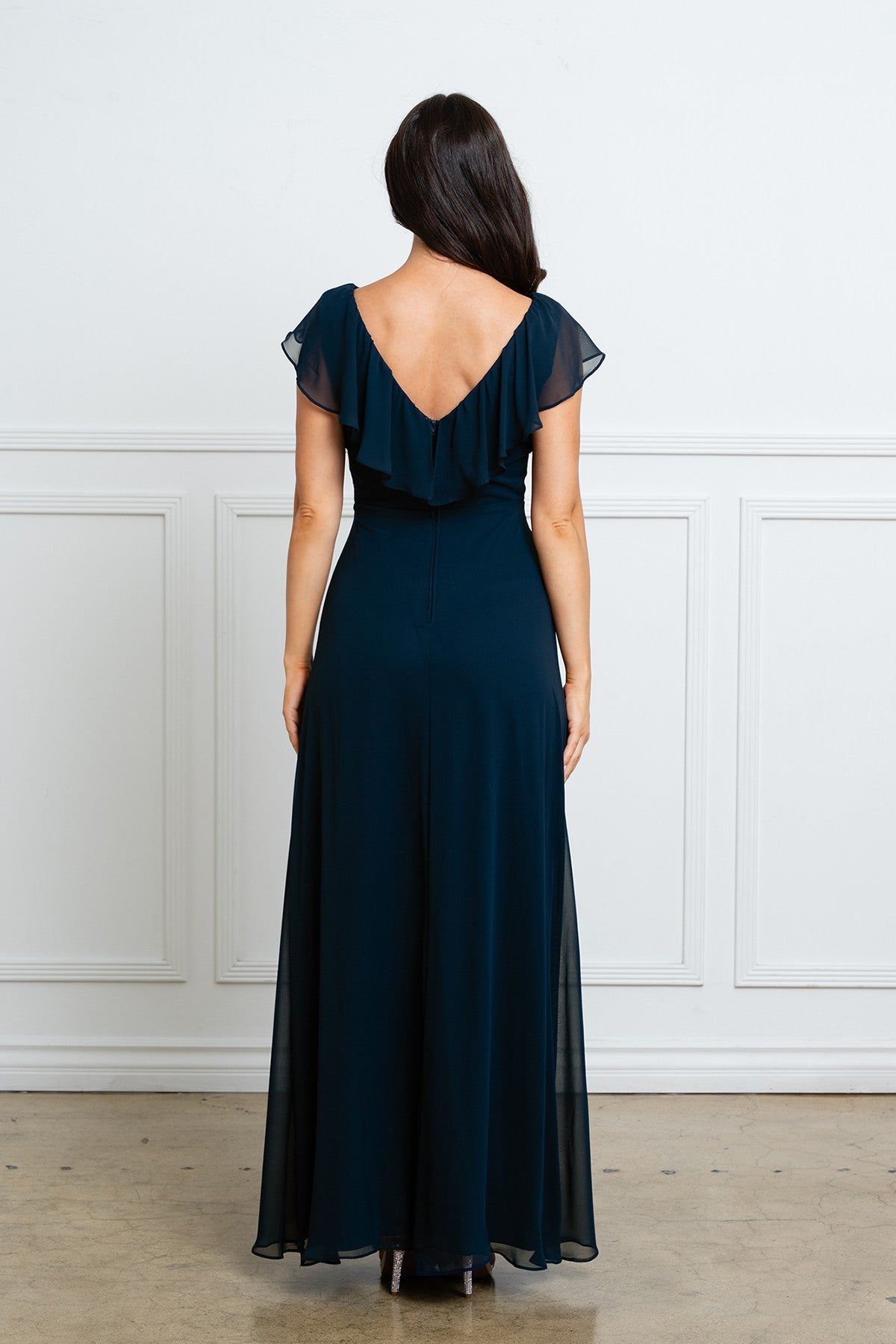 Dos de la robe longue bleu marine montrant la coupe ajustée à la taille et le tombé fluide du tissu en chiffon.
