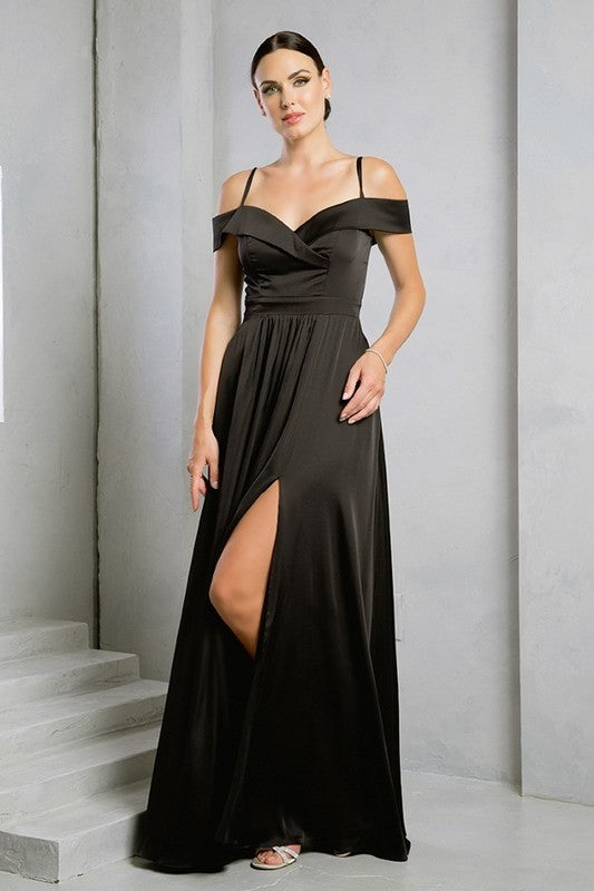 Femme portant une robe de soirée longue en satin bleu marine, coupe épaules dénudées avec fente haute sur la jambe, tenant une pochette dorée.