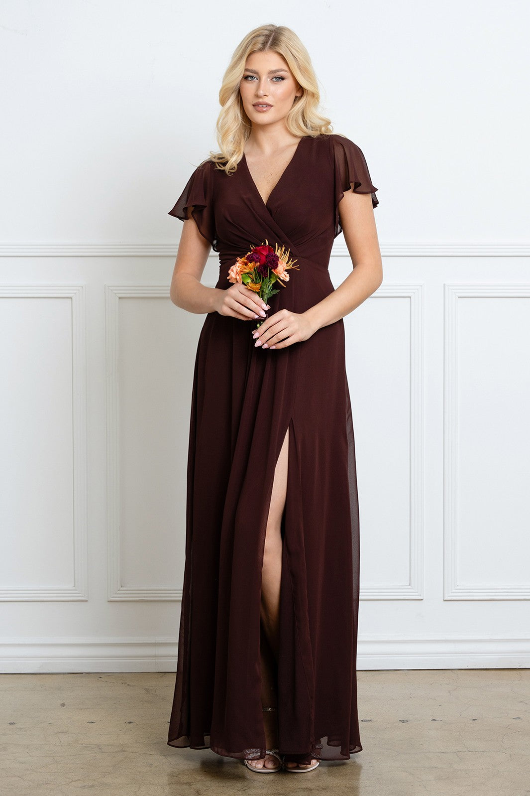 Robe longue de soirée chocolat avec décolleté en V croisé, manches courtes évasées et fente haute sur la jambe.