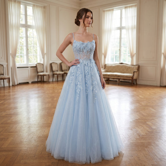 Mannequin portant une robe de bal longue de face, avec un bustier corset transparent orné de broderies de fleurs en relief et d'appliques de dentelle scintillantes, sur une jupe volumineuse en tulle brillant.