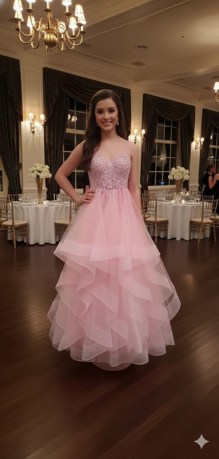 Robe de bal rose à volants de tulle vaporeux et bustier orné de sequins scintillants.